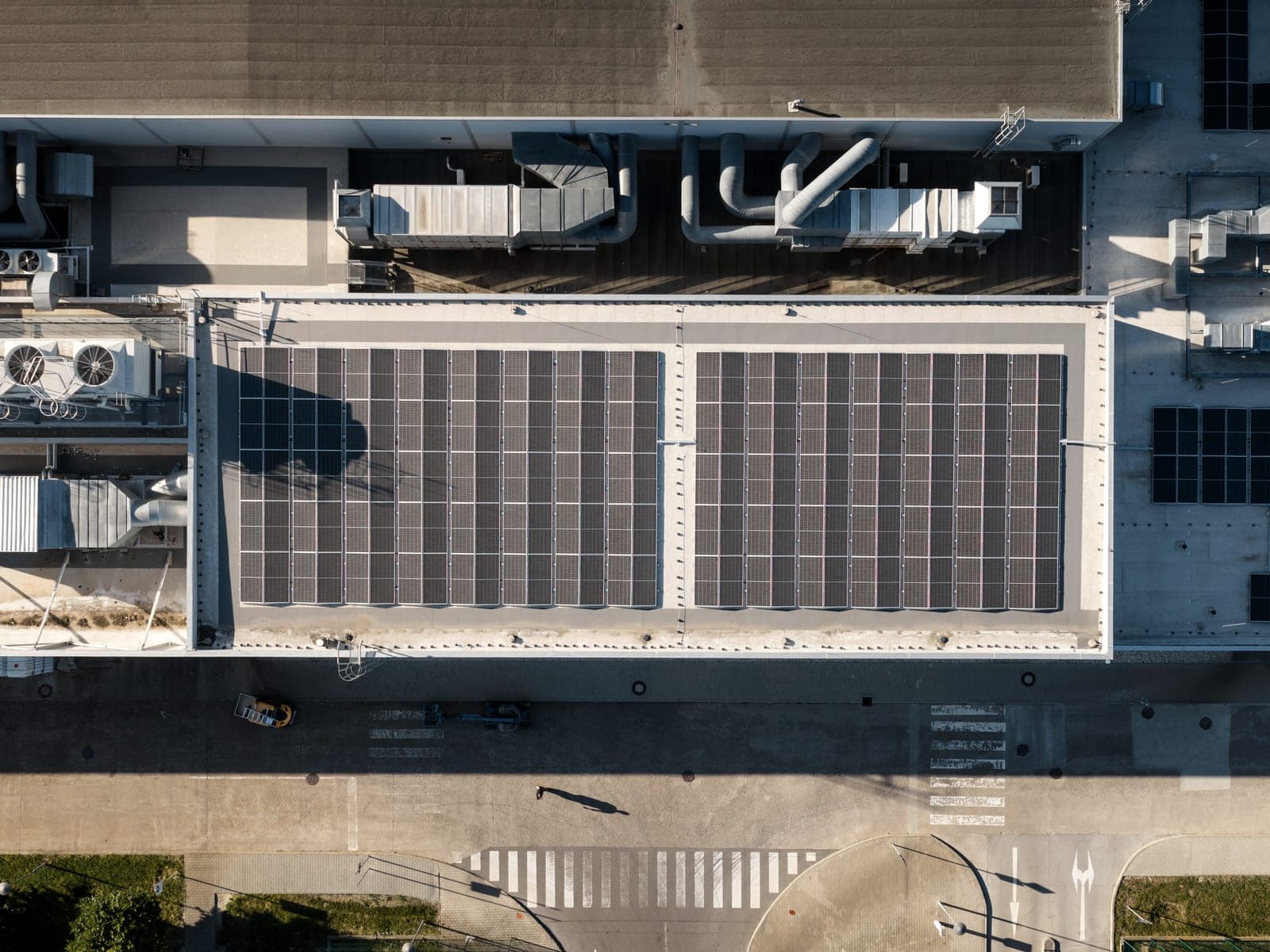 Kolmý pohled z dronu na střechu haly s fotovoltaickým polem