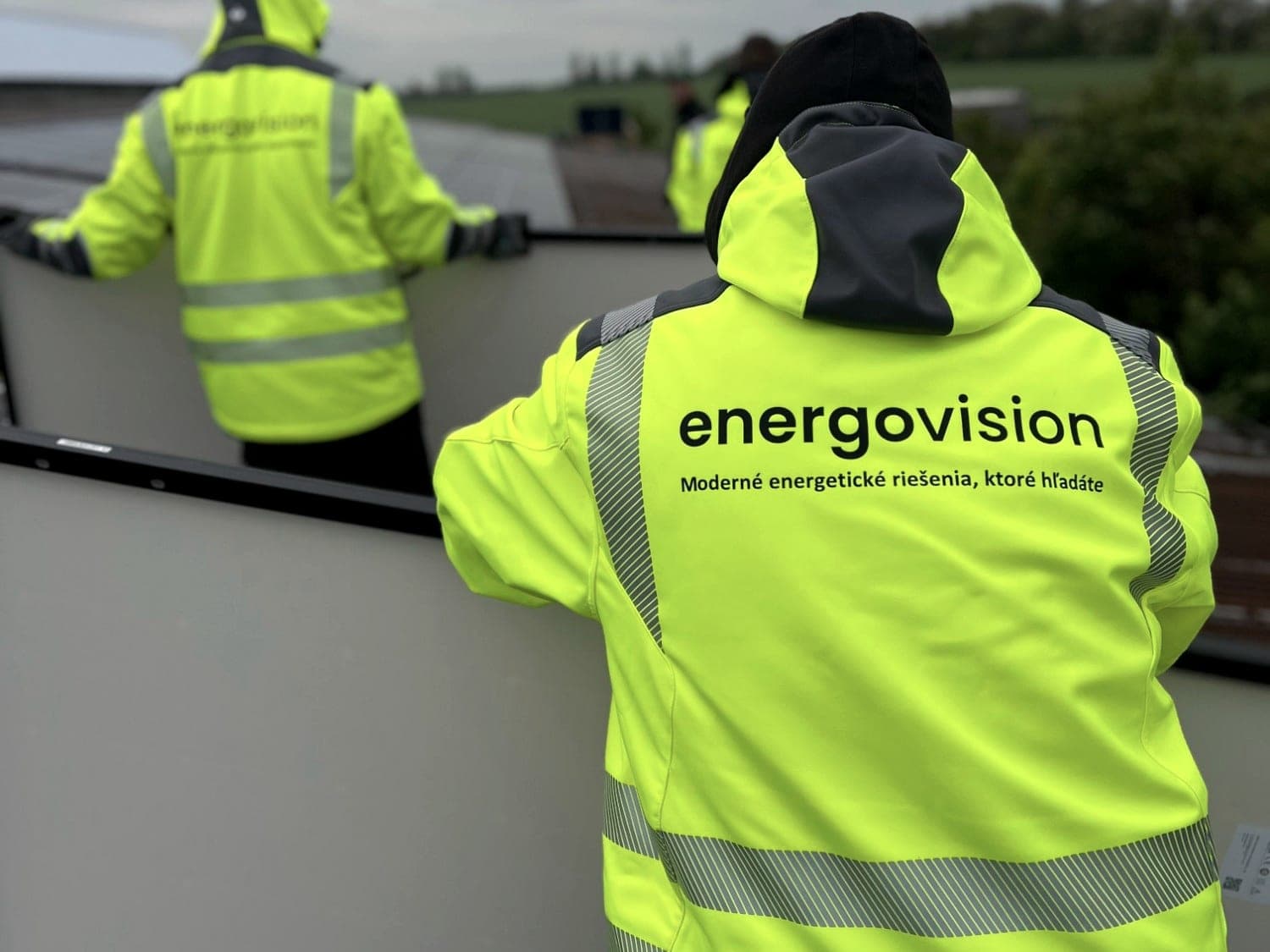 Montážní tým Energovision v reflexních bundách při instalaci panelů na střeše
