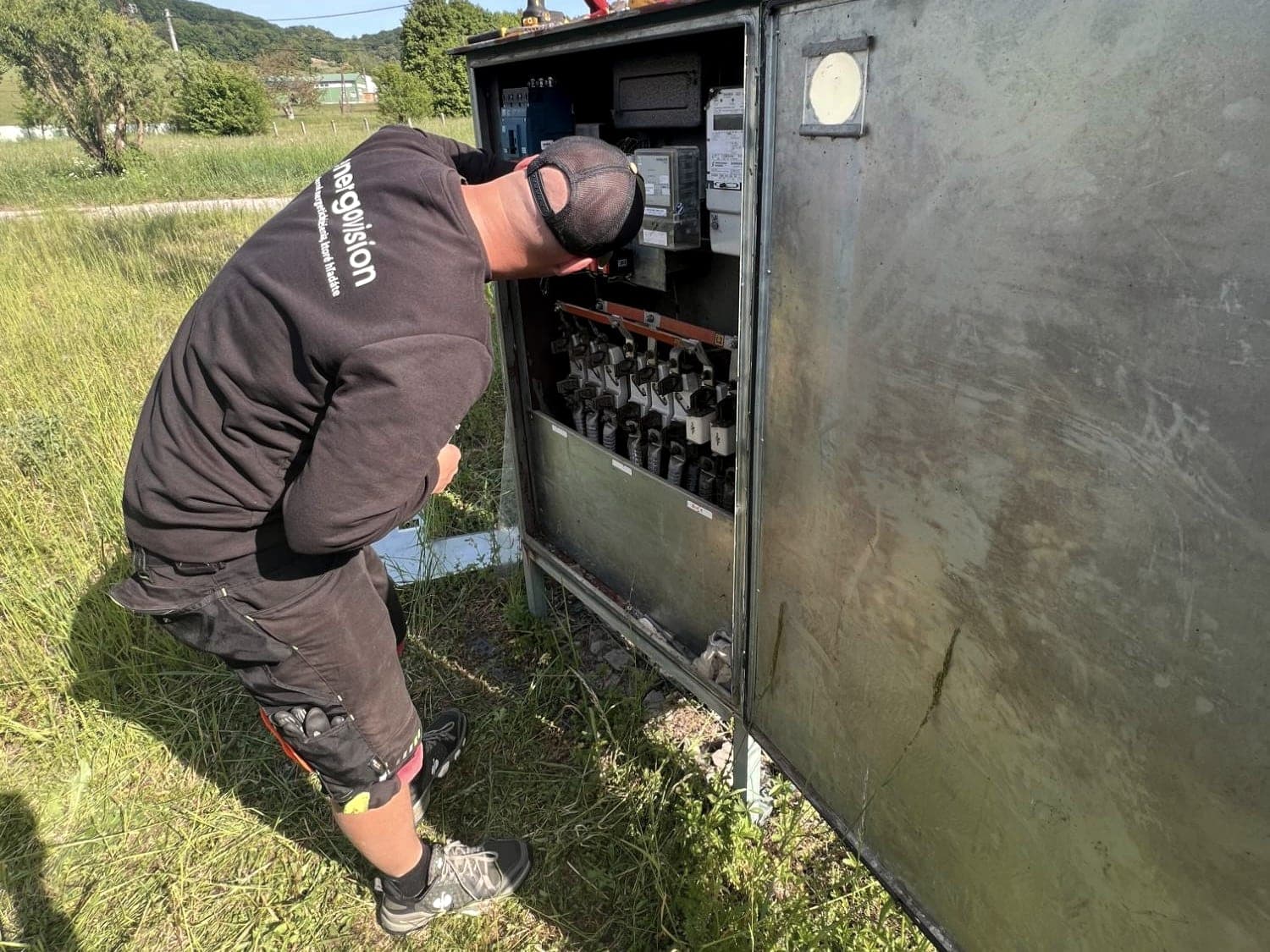 Elektrikář Energovision pracuje na NN rozváděči u stožárové trafostanice