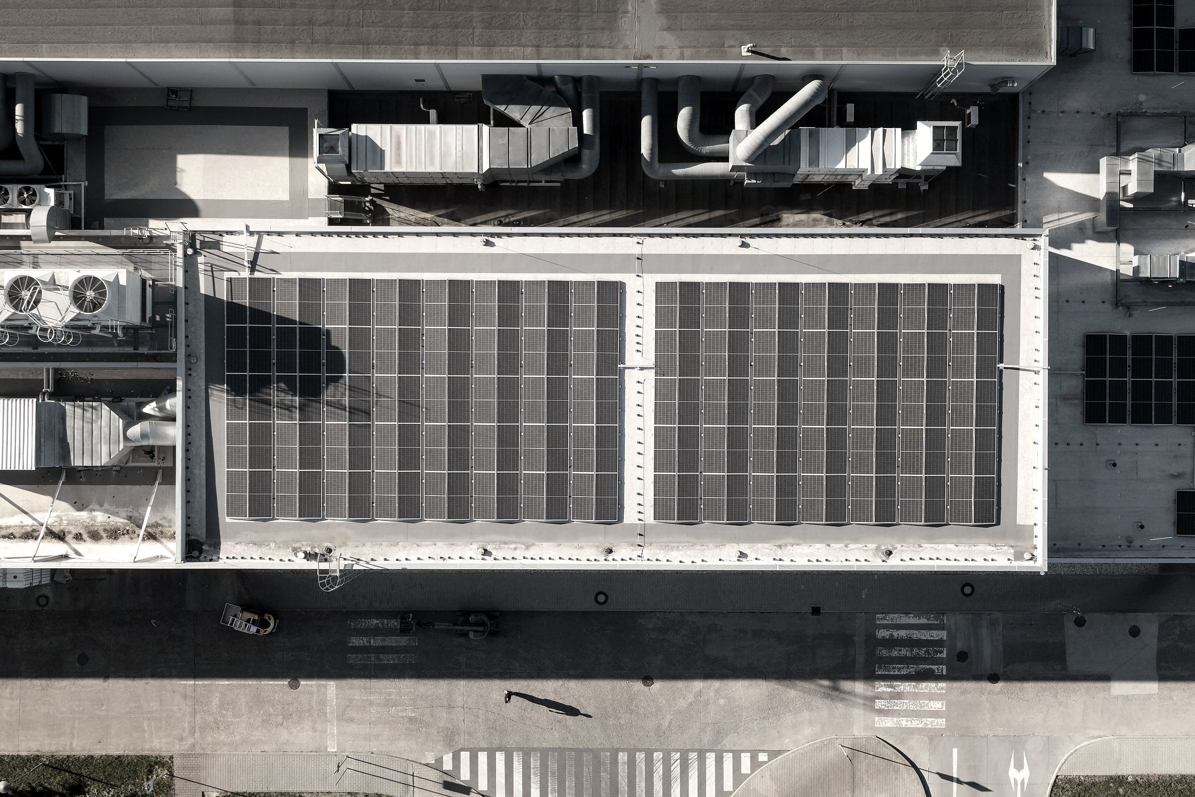 Kolmý letecký pohled na střechu výrobní haly se dvěma poli fotovoltaických panelů